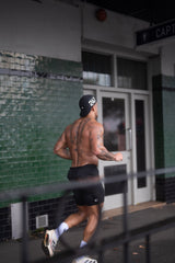 Marchon protein wholesale athlete running shirtless with tattoos on a city street for coffee shop wholesale